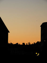 Silhouette buildings against sky during sunset
