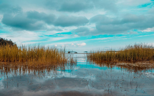 Scenic view of lake against cloudy sky