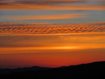 Scenic view of mountains against orange sky