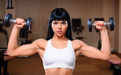 Beautiful young woman exercising in gym