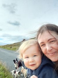 Portrait of happy mother and daughter against sky