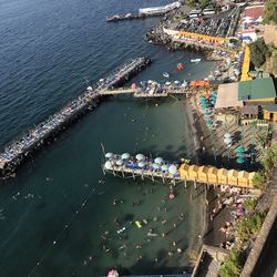 High angle view of crowd by sea against buildings in city