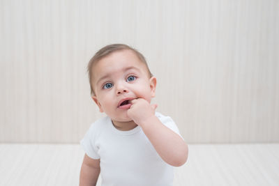 Portrait of cute boy against wall at home