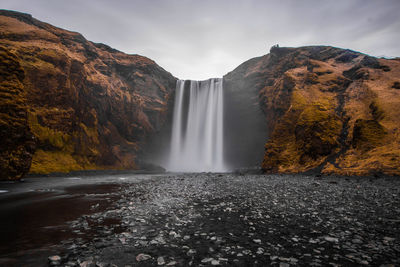 Scenic view of waterfall against sky