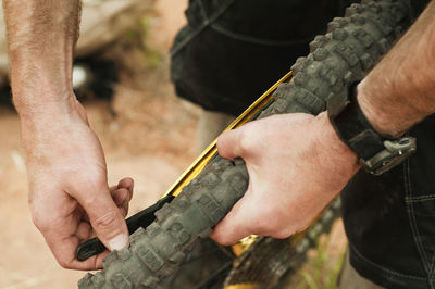 Cropped image of man fixing bicycle screw