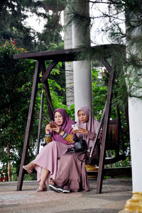 Portrait of smiling young woman sitting outdoors