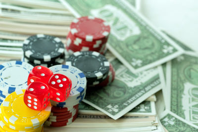 Close-up of gambling chips with money on table