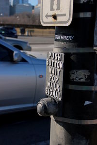 Information sign on pole against cars on street