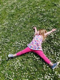 High angle view of girl lying on grassy field