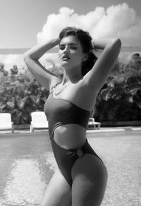 Young woman in bikini looking at swimming pool