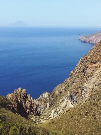 Scenic view of sea and mountains against clear sky