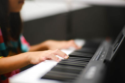 Cropped hands of woman playing piano