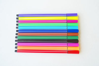 High angle view of colored pencils against white background