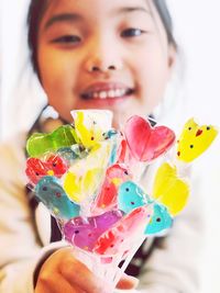 Close-up of young woman holding colorful candies