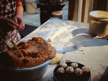 Midsection of woman preparing food at table