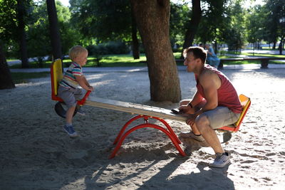 Full length of father and son on tree