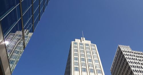 Low angle view of skyscrapers against clear blue sky