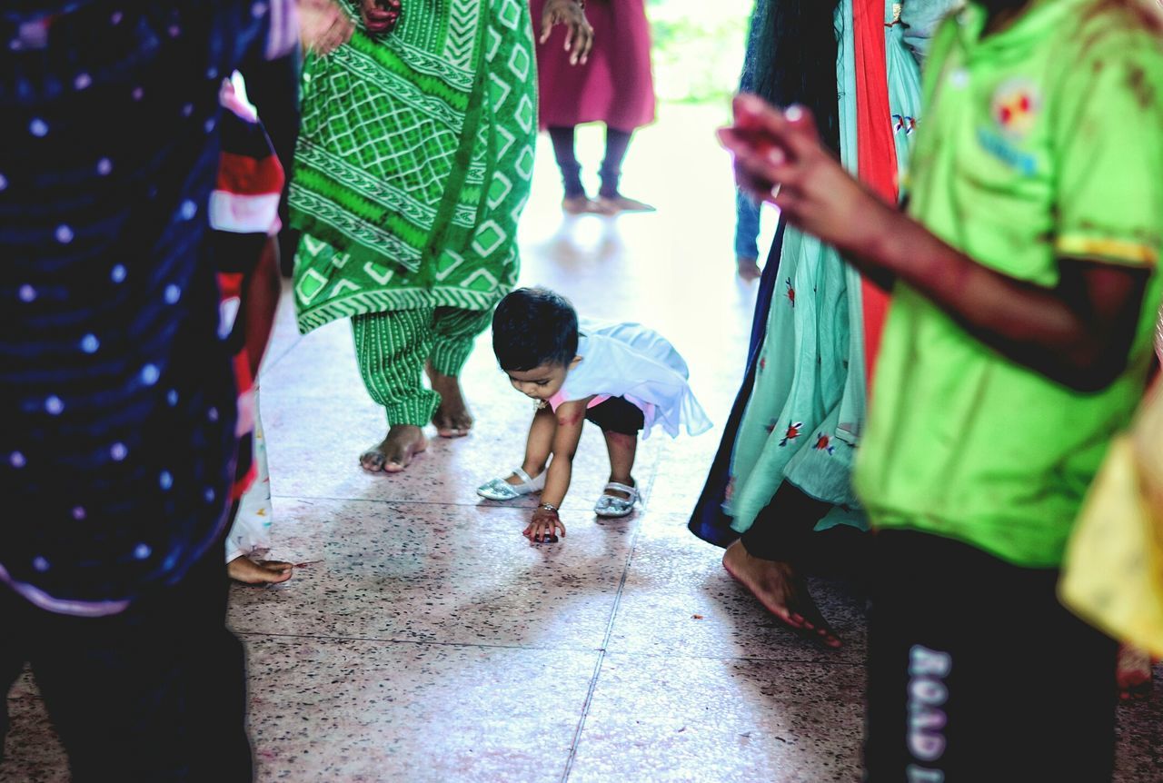 real people, childhood, incidental people, walking, boys, street, lifestyles, green color, day, full length, casual clothing, high angle view, leisure activity, outdoors, togetherness, girls, men, standing, playing, women, low section, people