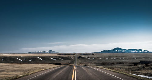 Road leading towards mountain against sky