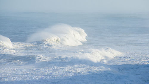 Aerial view of sea against sky and waves