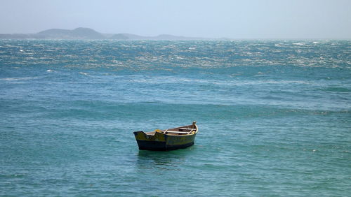 Boat moored in sea against sky