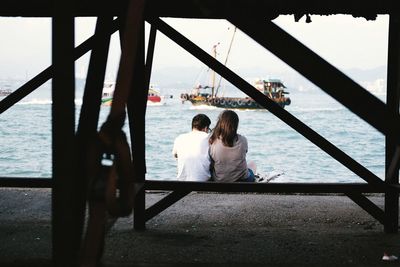 Rear view of people on boat in front of sea