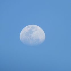 Low angle view of moon against clear blue sky