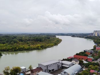 High angle view of river amidst buildings against sky