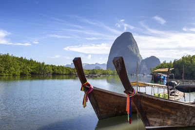 Boat moored on river against sky