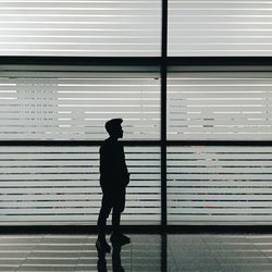 Rear view of silhouette man standing against wall