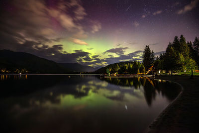 The northern lights and a shooting star in whistler, bc. on a calm evening at lakeside park