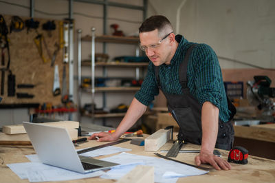 Side view of man working at table