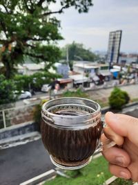 Close-up of hand holding drink in city