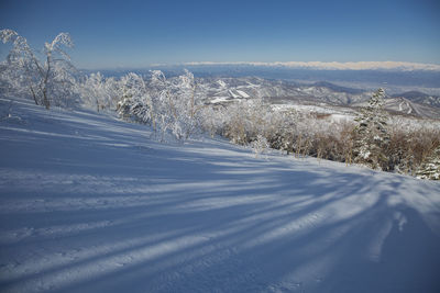 Snow covered landscape against sky