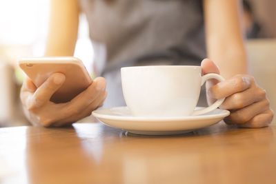 Close-up of hand holding coffee cup