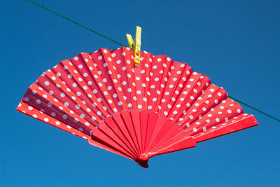 Low angle view of illuminated flag against clear blue sky