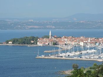 High angle view of city by sea against sky