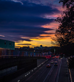 Cars on road against sky during sunset