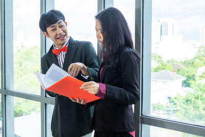 Young couple standing by window