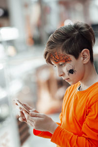 Side view of boy using mobile phone