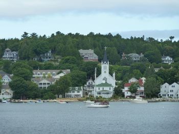 Town by river against sky