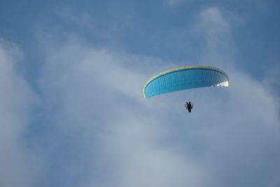 Low angle view of paragliding against sky