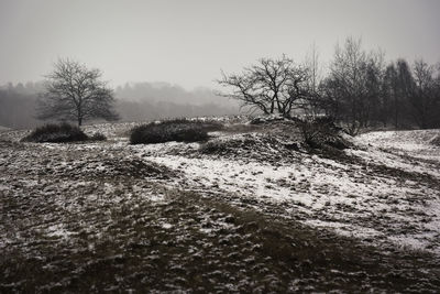 Snow covered landscape against clear sky