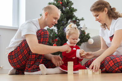Parents with daughter playing with blocks at home