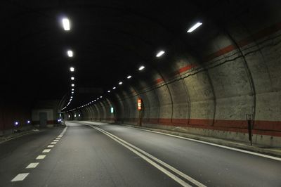 Empty road in illuminated tunnel