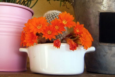 Close-up of orange flower vase on table