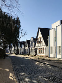 Houses by street against sky