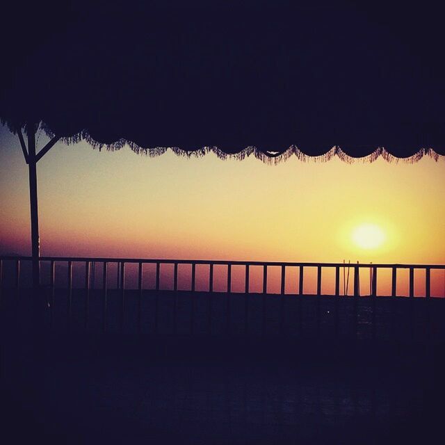 silhouette, sunset, railing, clear sky, fence, sky, tranquility, tranquil scene, connection, nature, built structure, scenics, beauty in nature, copy space, bridge - man made structure, sea, outdoors, street light, protection, dusk