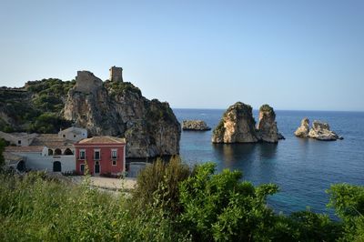 Scenic view of sea and buildings against clear sky