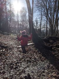 Man amidst trees in forest against sky during autumn